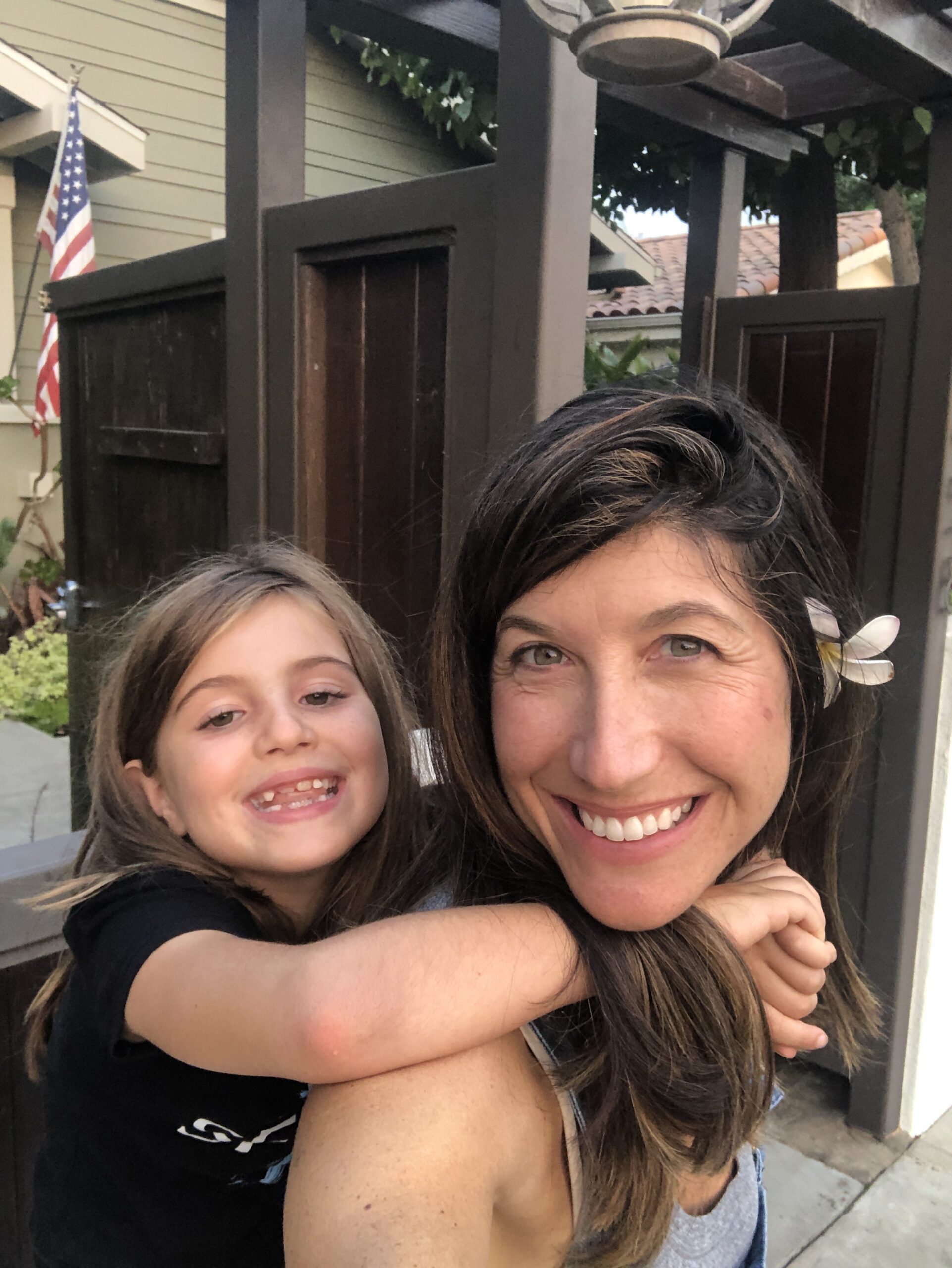 Smiling mother and daughter piggy back ride