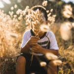 picture of a child holding wheat in front of face