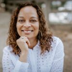 Woman smiling at camera with white long sleeve shirt