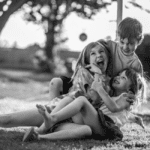 black and white picture of three children playing/wrestling