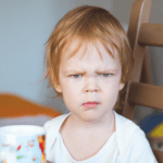 red hair toddler looking angrily at the camera