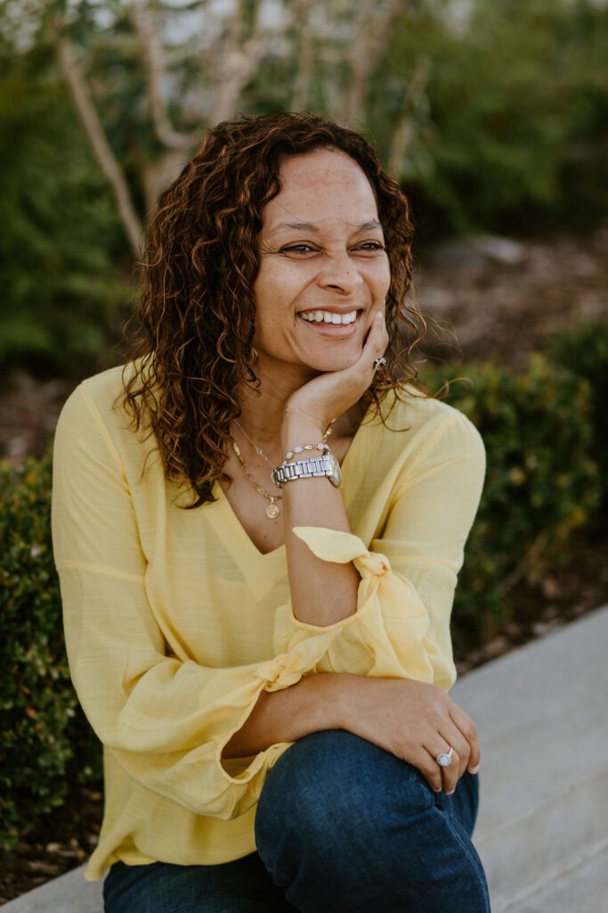 woman sitting down looking away from camera and smiling